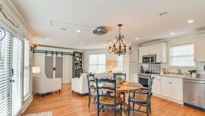 A spacious kitchen with a dining area, wooden flooring, white cabinetry, and a chandelier. - Tranquil Arrington Cottage ~ 7 Mi to Franklin! (Arrington)