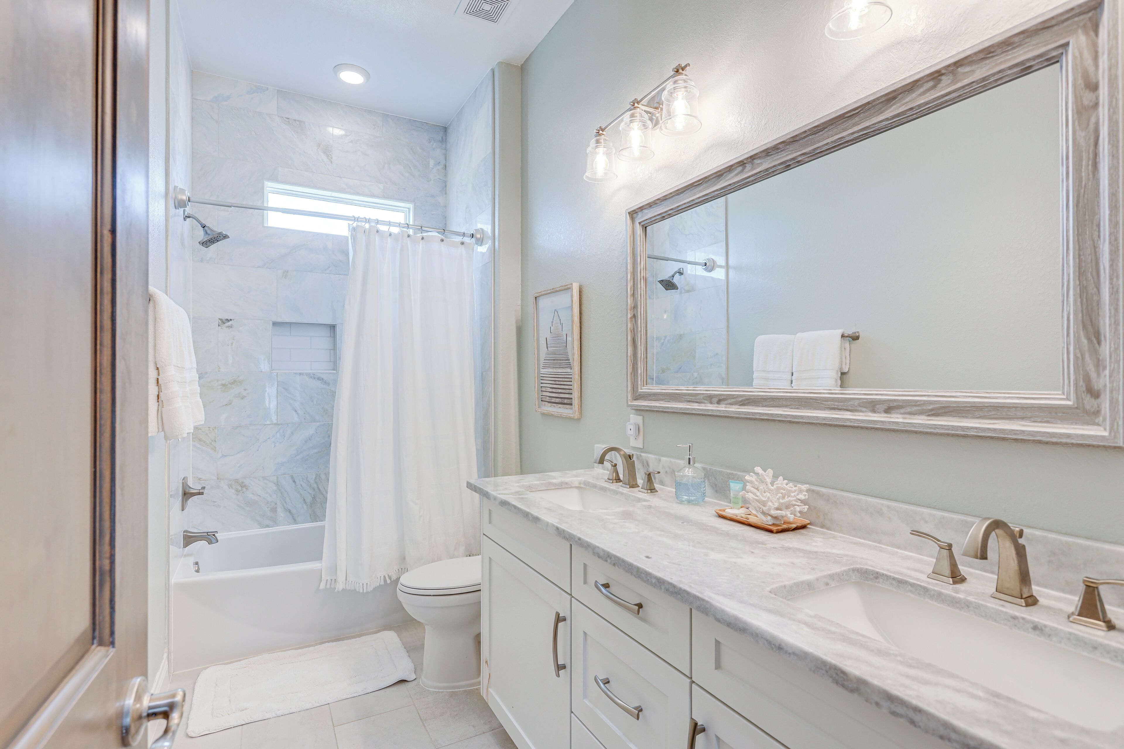 A bathroom with a bathtub, toilet, and sink.