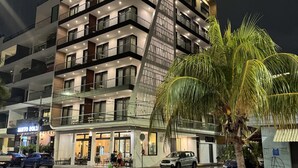 A modern multi-story hotel with balconies, a restaurant, and a visible palm tree. - Alizee Tower (Playa del Carmen)