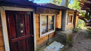 A rustic wooden building with a metal chimney, a wooden door, and a small window. - Residencial El Cielo a Wonderful Place in the mountain range at Los Naranjos ESV (Los Naranjos)