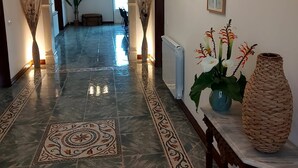 A hallway with a marble floor, a ceiling fan, and framed artwork on the walls. - Spacious 4 bed house with hot tub, games room & terraces, near Alcobaca & Nazare (Vestiaria)