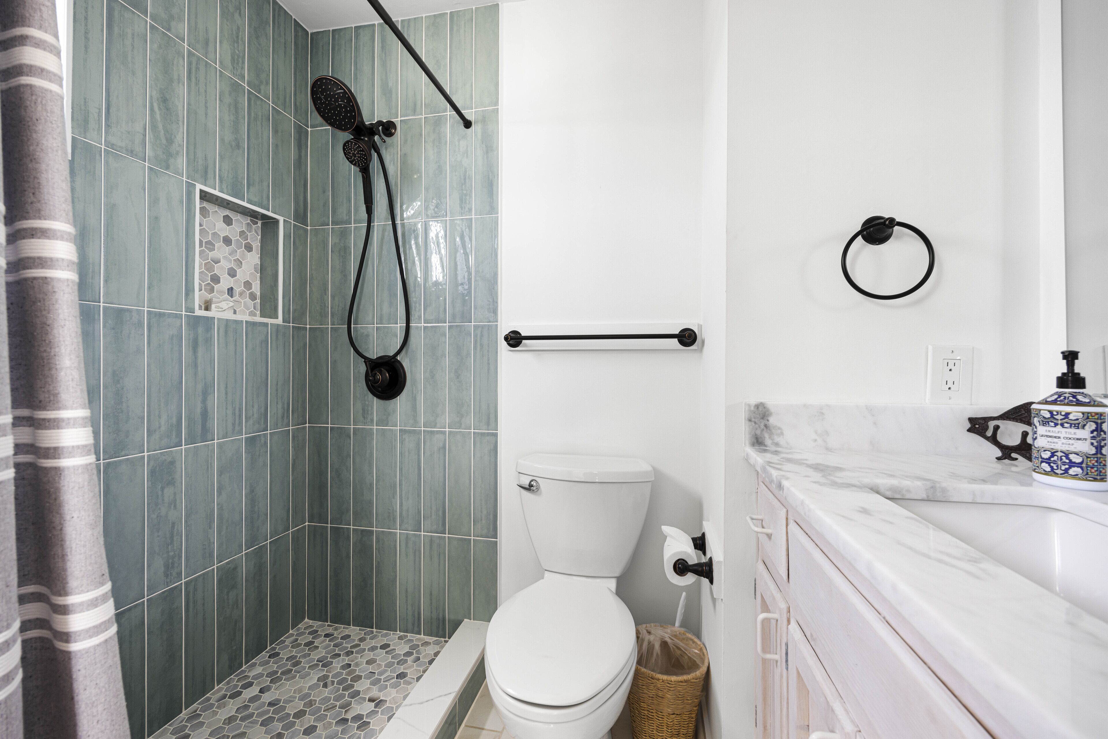 Un bagno con doccia, WC e un piano di marmo.
