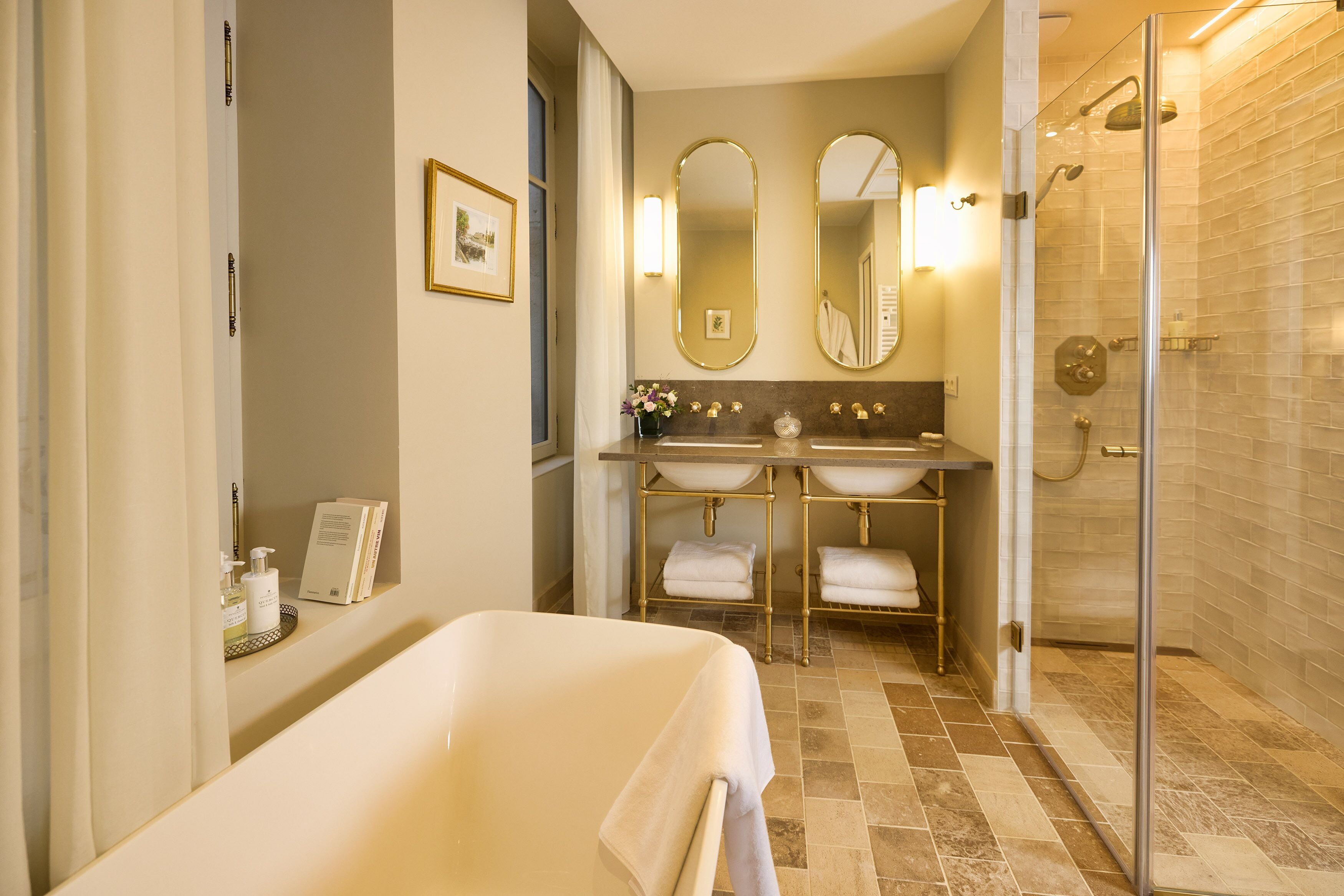 Un baño con bañera, dos lavamanos y ducha.