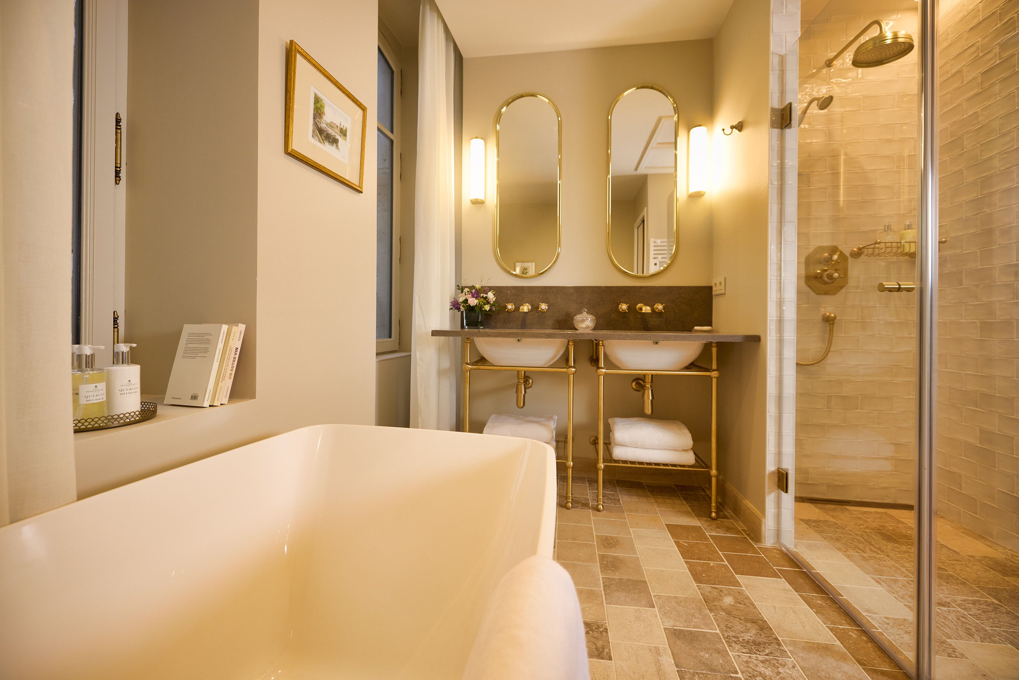 Une salle de bain moderne avec une baignoire, deux lavabos et une douche à parois de verre.