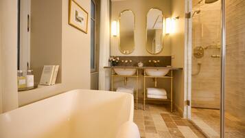 Une salle de bain moderne avec une baignoire, deux lavabos et une douche à parois de verre.