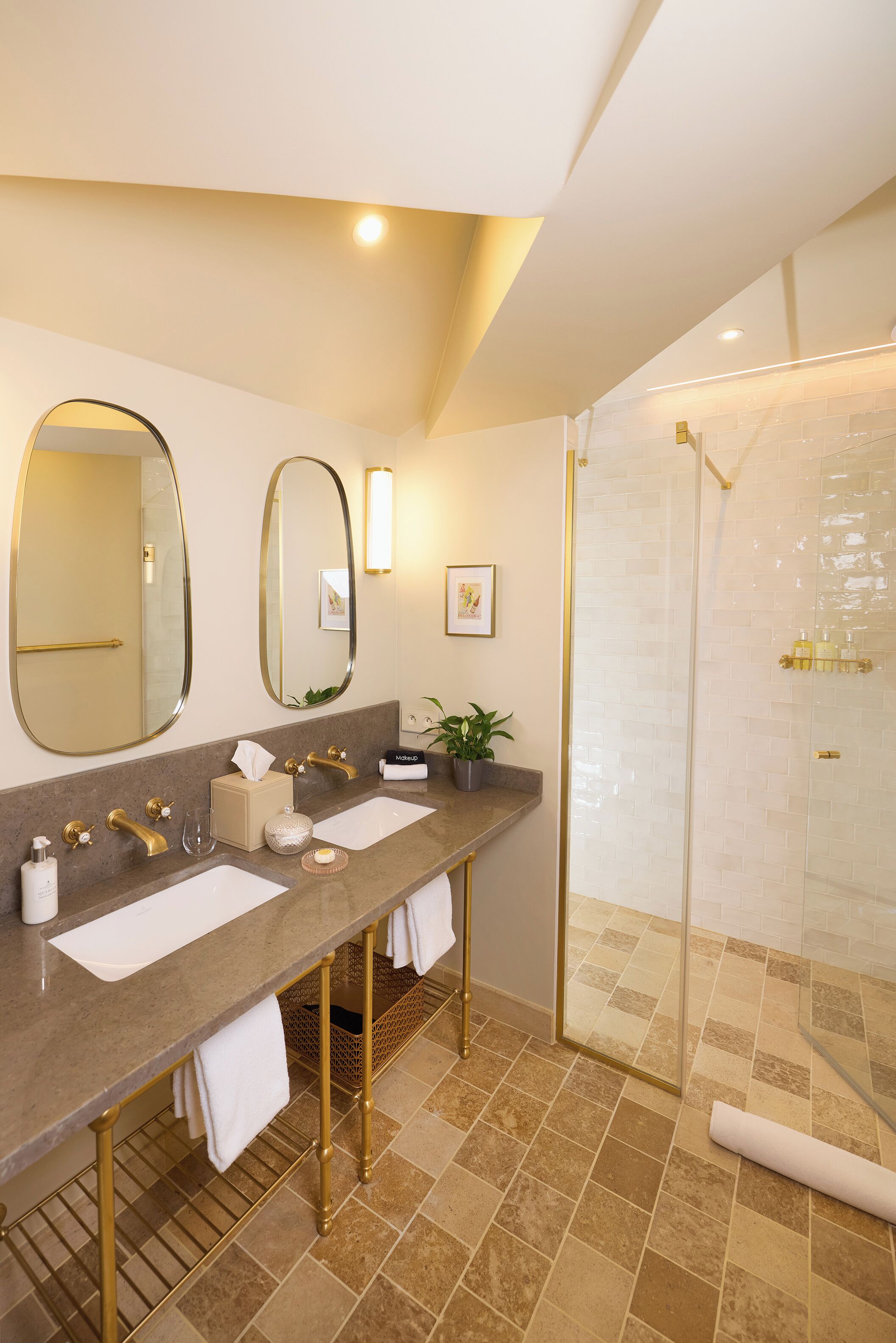 A modern bathroom with two sinks, a large mirror, a shower, and a towel rack.