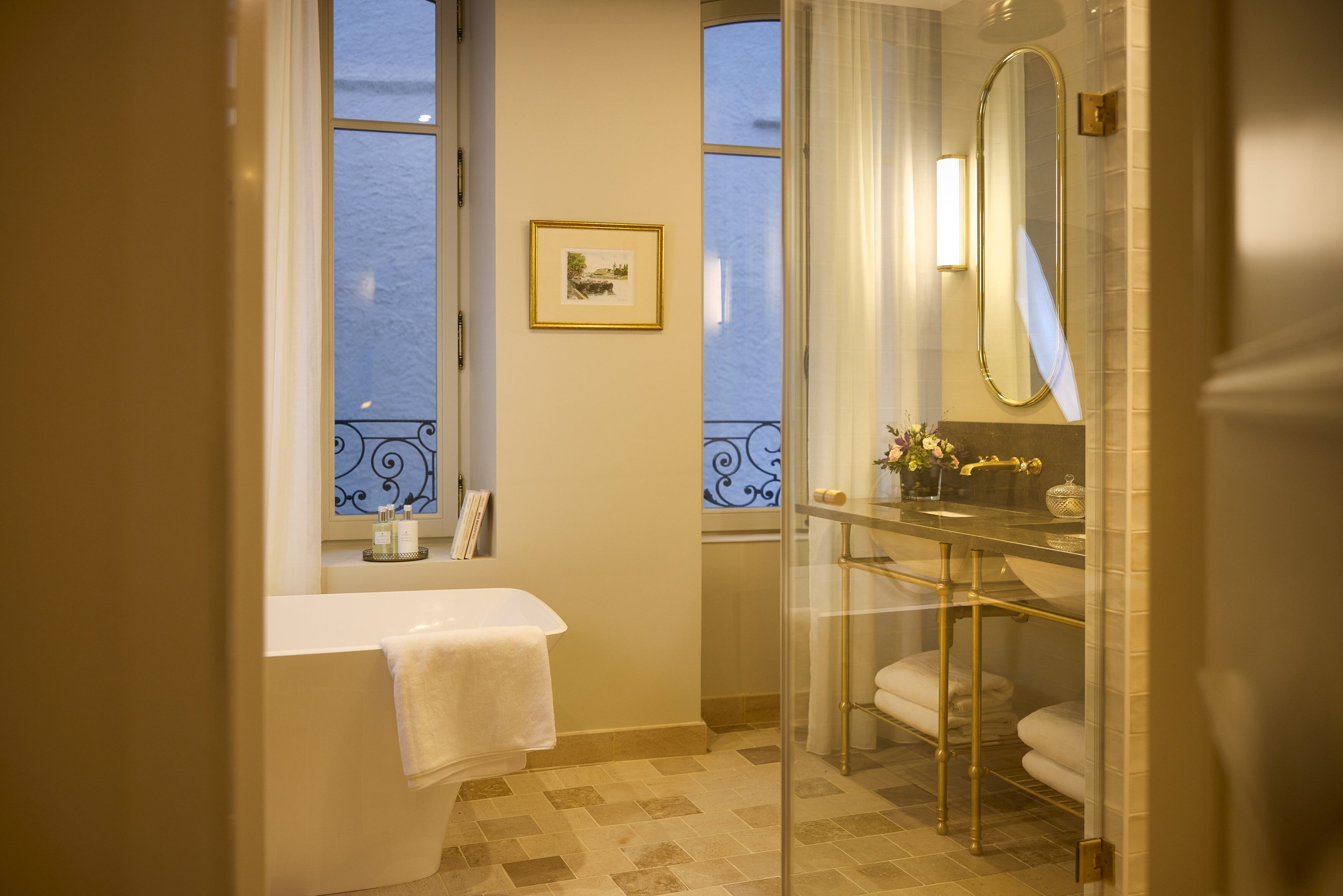 A bathroom with a bathtub, a glass-enclosed shower, and a large mirror.