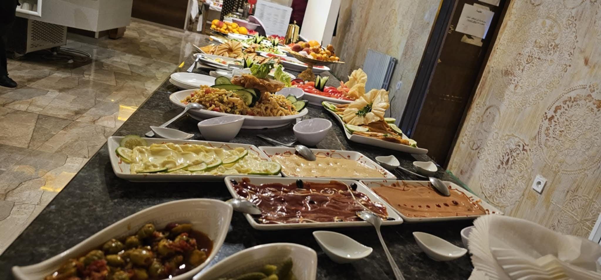 A buffet with various dishes including pasta, salads, and meats.