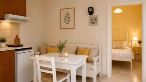 A kitchen with a white table, a white sofa, and a dining area.