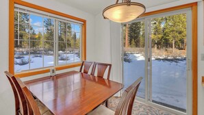 A dining room with a large wooden table, four chairs, and a chandelier. - Single-Level 3BR | AC | River, Trails (Bend)