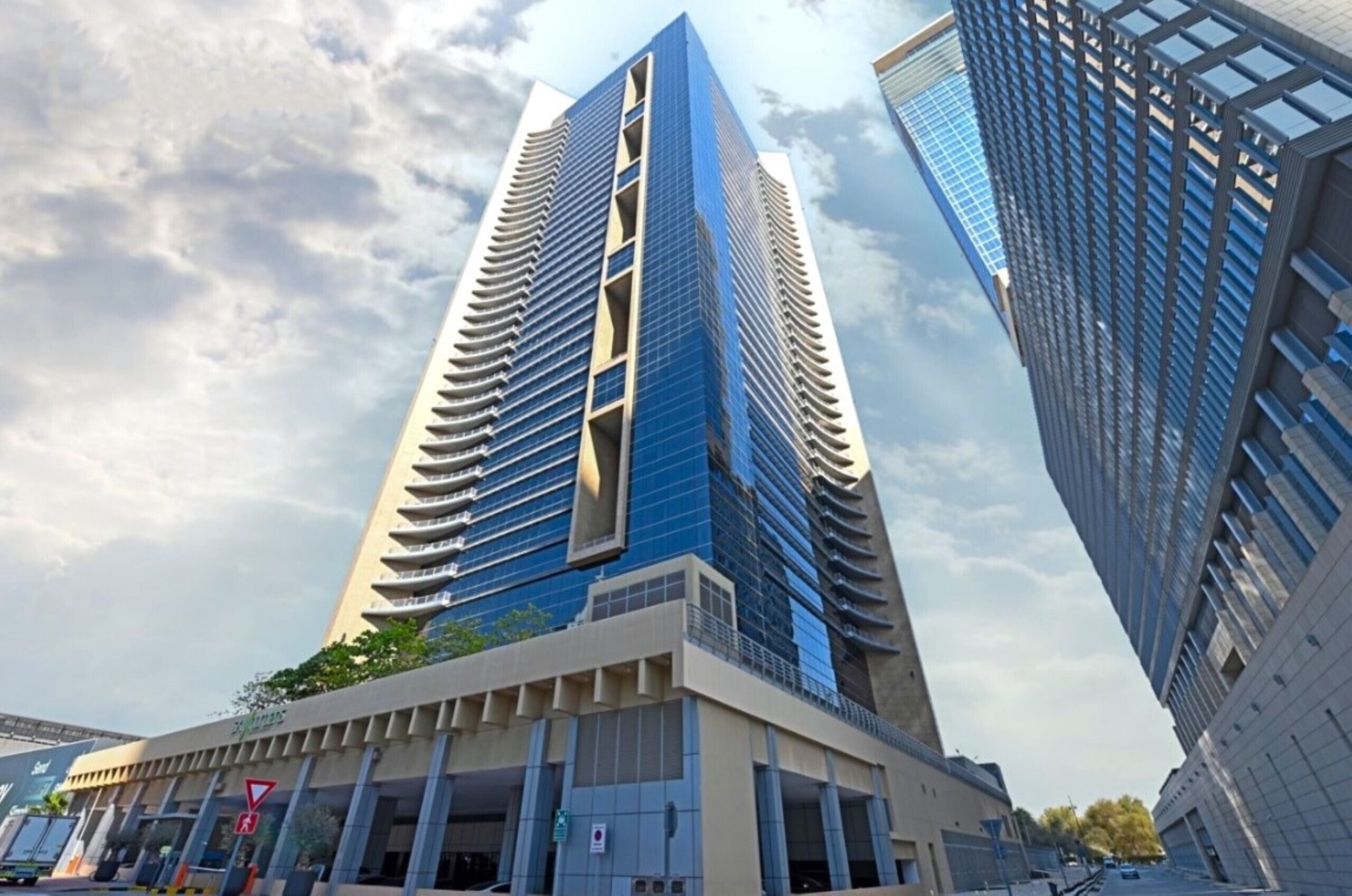 A modern high-rise building with a glass facade and a unique architectural design featuring a series of balconies.