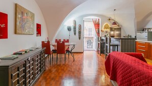 A spacious loft with a dining area, kitchen, and a large window.