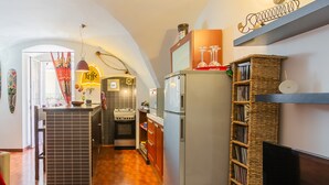 A compact kitchen with a central island, a built-in oven, and a refrigerator.