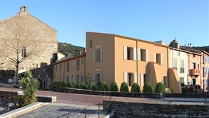 A stone building with a flat roof and a large window. - Appartement - Vue sur Mer (Collioure)