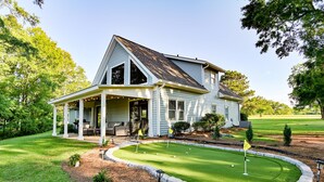 A house with a porch, a lawn, and a putting green. - Walk to Dinner! Waterfront, Updated, Prime Location - Back Home Oconee (Eatonton)