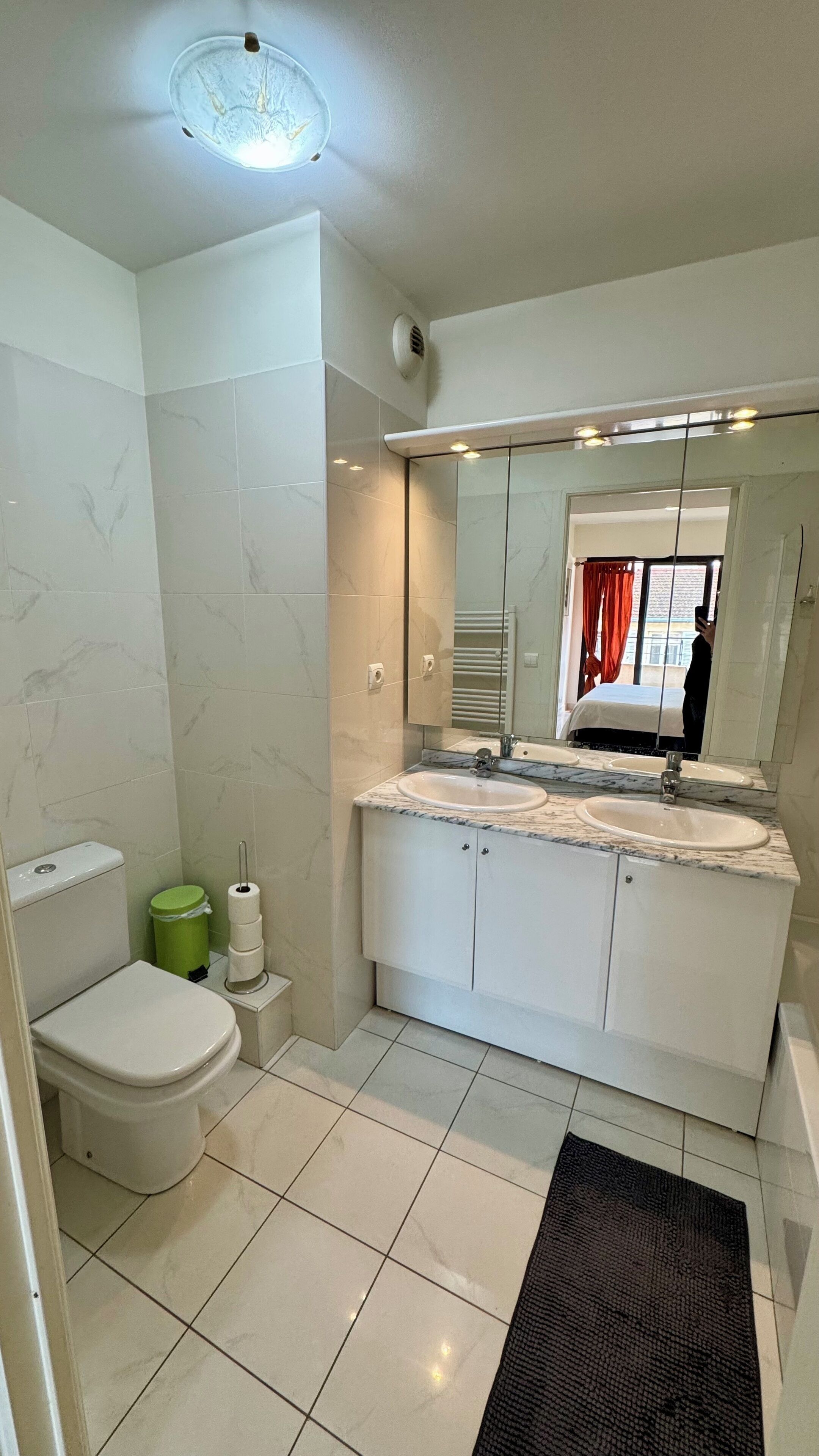 Ein modernes Badezimmer mit Toilette, Waschbecken und Spiegel.