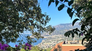 A wooden fence with purple flowers, overlooking a coastal town with red-roofed buildings and a clear blue sky. - Family-friendly sea-view villa with enclosed garden & BBQ near Sorrento (Sorrento)