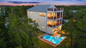 A two-story house with a swimming pool, surrounded by trees. - New, Loaded! 6-Seater LSV, 6 Bikes, Private Pool, Walk to Beach! (Santa Rosa Beach)