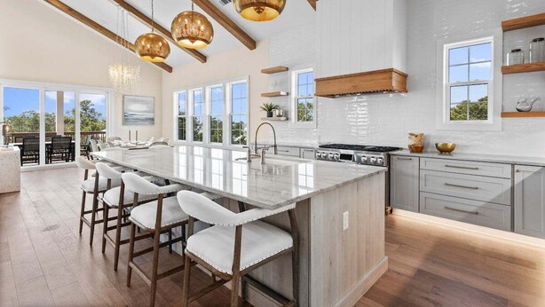 A spacious kitchen with a large island, wooden beams, and pendant lighting. - New, Loaded! 6-Seater LSV, 6 Bikes, Private Pool, Walk to Beach! (Santa Rosa Beach)