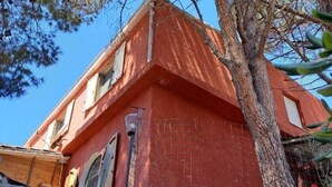 Um edifício vermelho com parede de tijolos e porta de madeira.