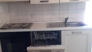 Cozinha equipada com lava-louças, forno e pia.