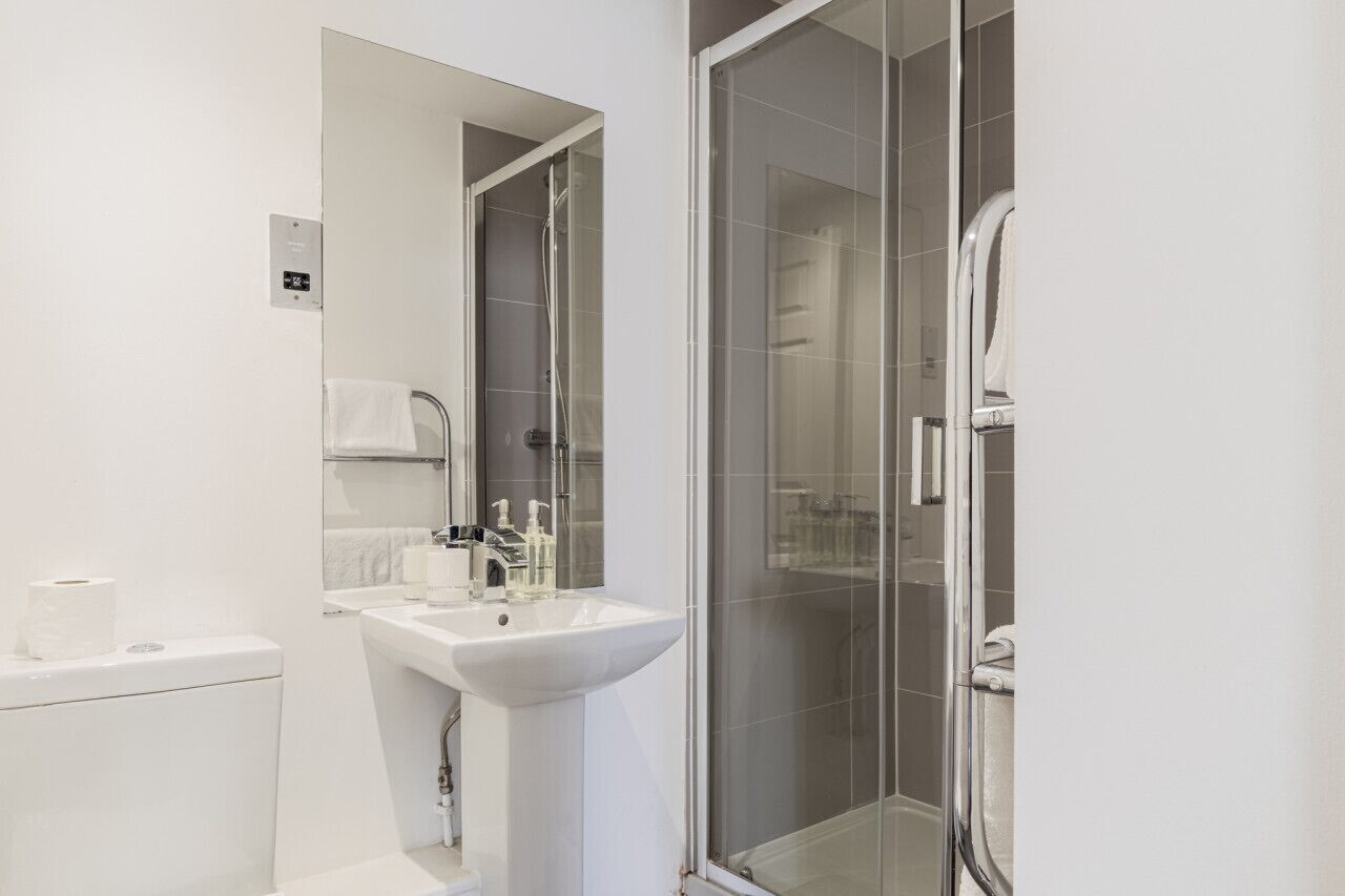 Een moderne badkamer met toilet, wastafel en douchecabine.