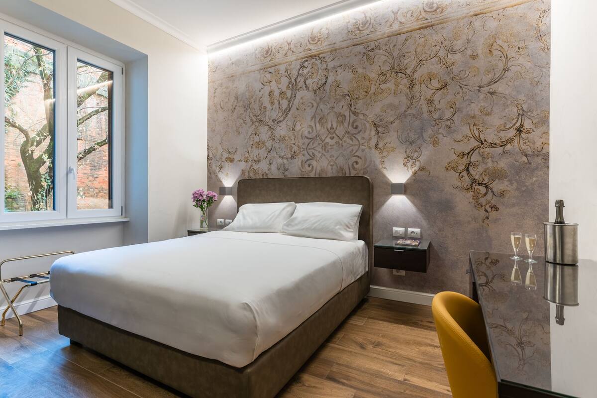 Une chambre à coucher moderne avec un grand lit, une table de chevet, une commode et une chaise.
