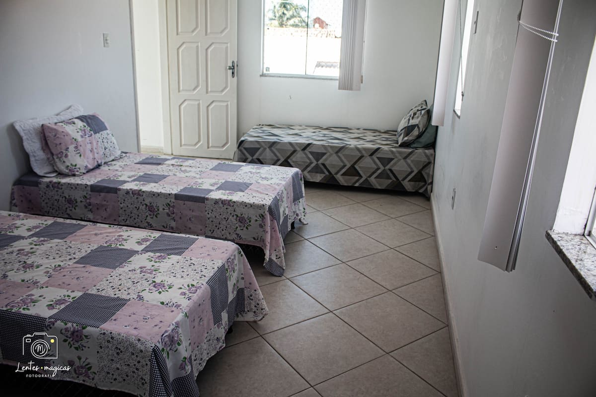 Ein Zimmer mit zwei Betten, eines mit einer blumigen Tagesdecke und das andere mit einem geometrischen Muster.