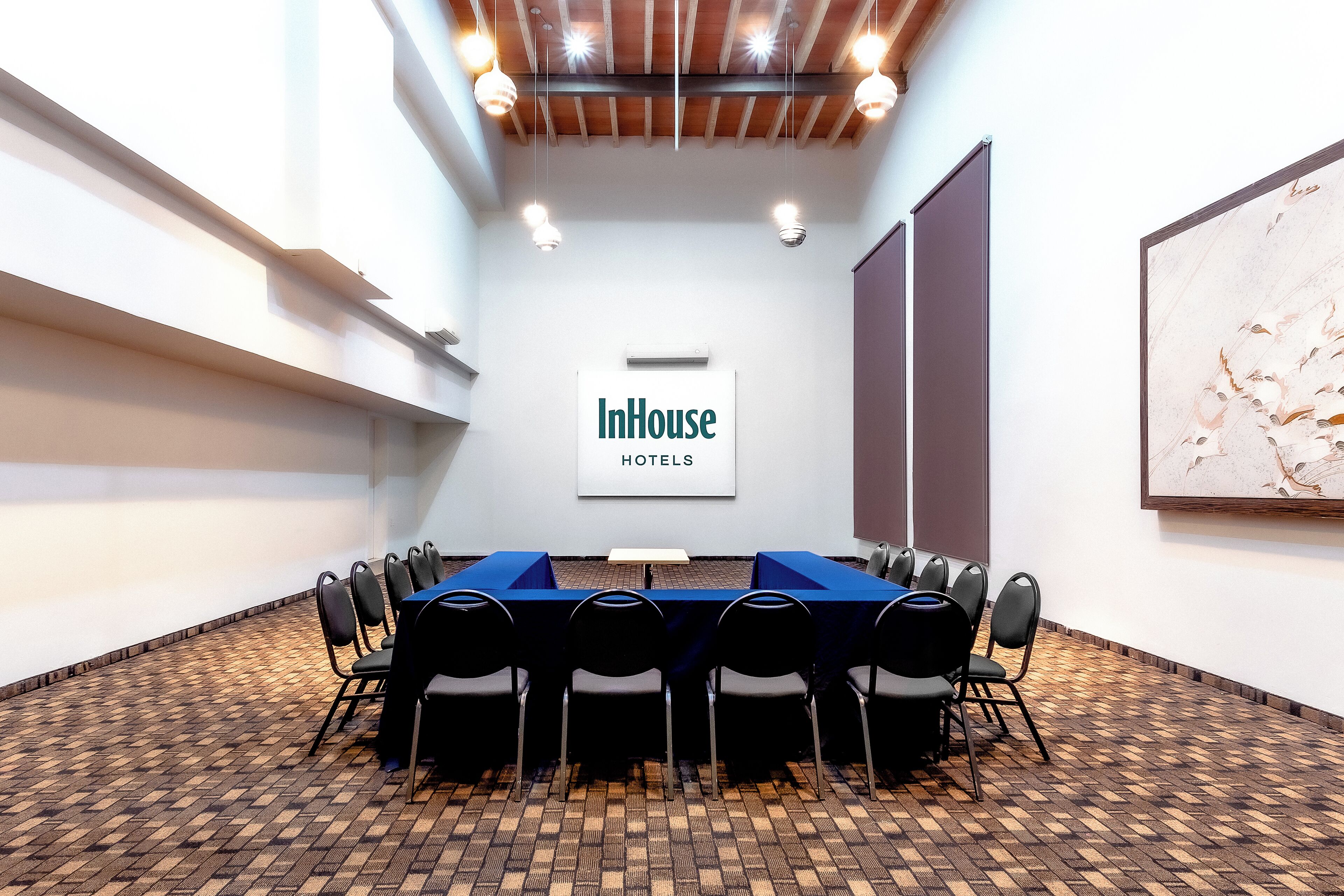 Un salón de conferencias con una larga mesa, sillas y un letrero que dice "InHouse HOTELS".