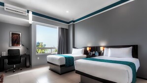 Une chambre d’hôtel avec deux lits, un bureau et une chaise.