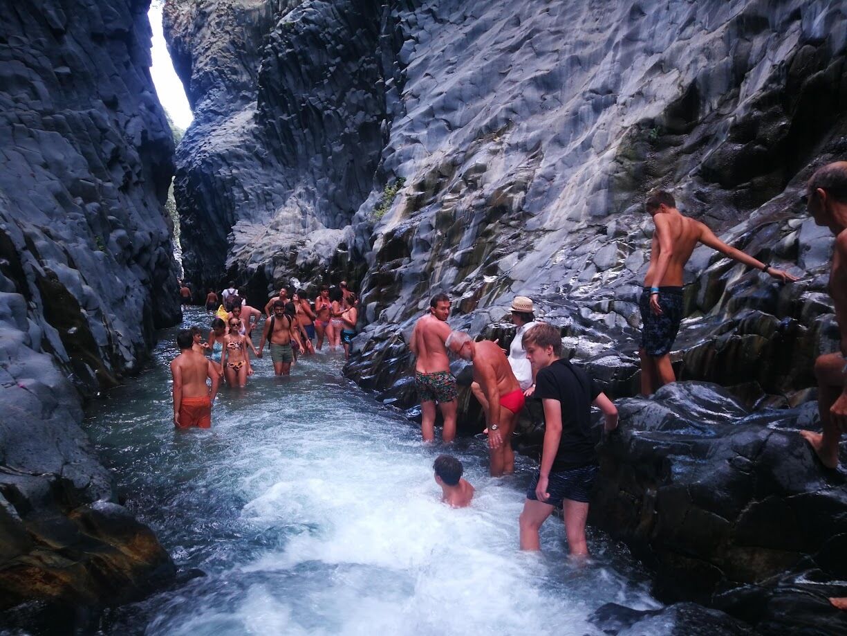 A group of people in a rocky, narrow water channel.