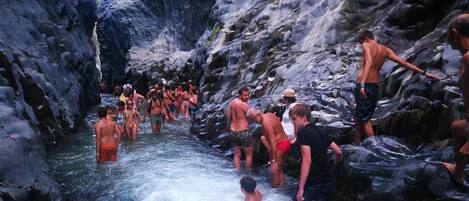 A group of people in a rocky, narrow water channel.