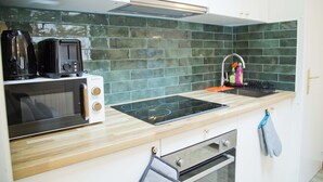 Una cocina equipada con microondas, tostadora, estufa a gas y horno.