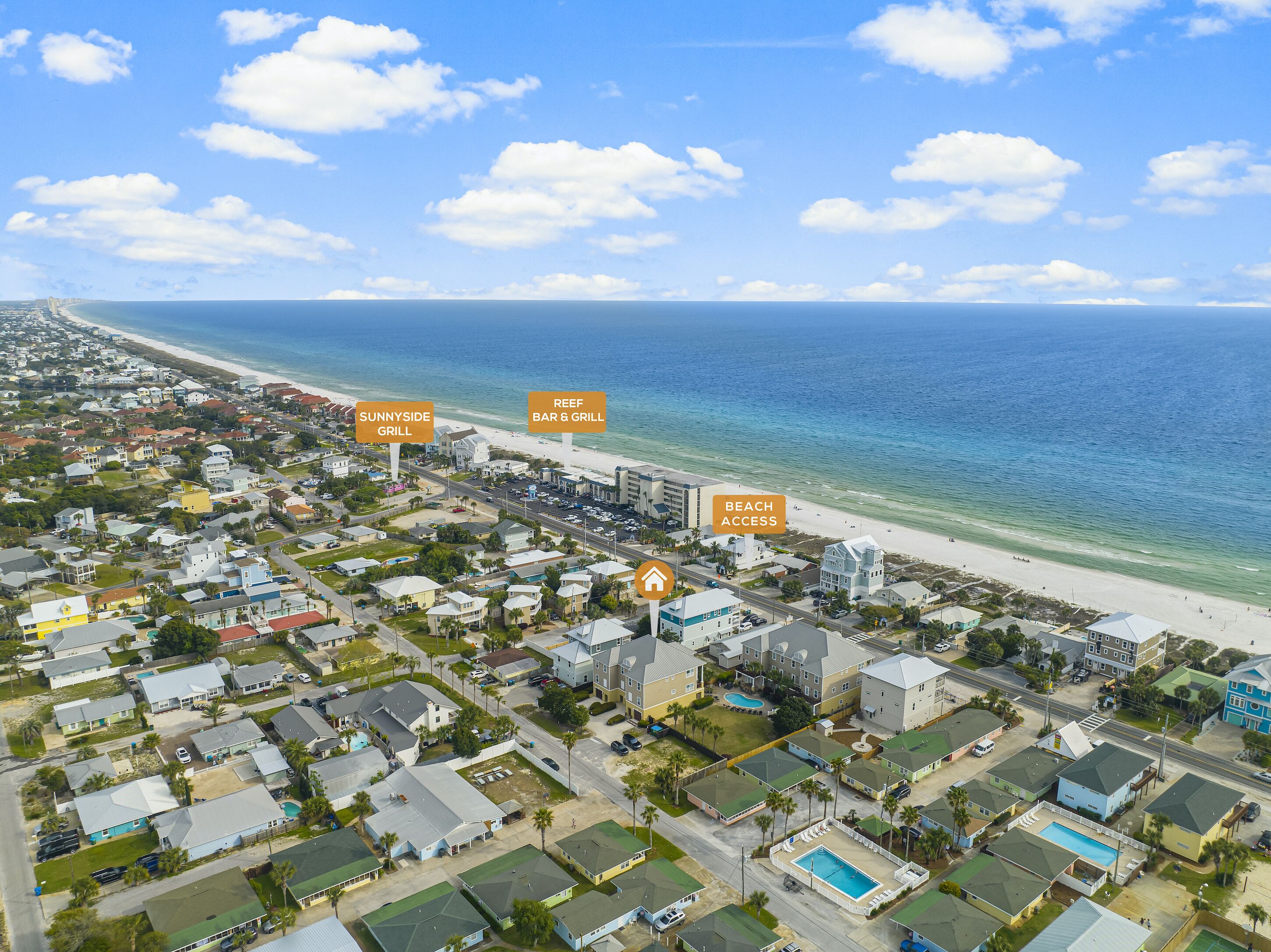 An aerial view of a coastal residential area with houses, a beach, and labeled amenities including a Sunnyside Grill and a Reef Bar & Grill.