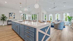 A spacious kitchen with a large island, pendant lighting, and a ceiling fan. - Rooftop Deck, Private Pool and Game room! Perfect for Families! (Anna Maria)