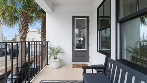 A modern balcony with a potted plant, a bench, and a door leading to an interior space. - Experience Seajoy! 200 yard walk to beach! (Orange Beach)
