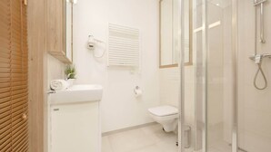 Ein modernes Badezimmer mit Toilette, Dusche und einer gläsernen Duschkabine.