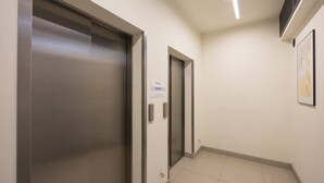 Ein Flur mit zwei Aufzugtüren, eine beschriftet mit 'RECIPIENT' und die andere mit 'WATER'.