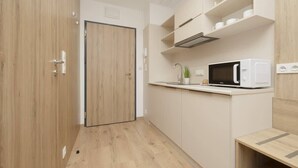 Eine kleine Küche mit einer Mikrowelle, einem Spülbecken und einer Arbeitsplatte.