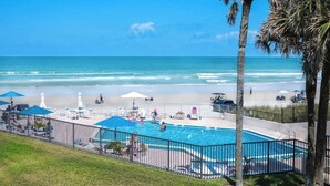 A pool area with a view of the beach and ocean. - Gorgeous Beach Front Condo, Near Flagler Ave - 701 (New Smyrna Beach)