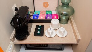 A kitchen counter with a coffee maker, tea infuser, teapot, cups, and a framed picture of a tea set. - Gray Hotel Casablanca (Casablanca)