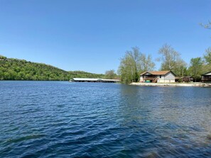 Ein Anwesen am Seeufer mit einer Anlegestelle, einem Haus mit Veranda und einem Boot.