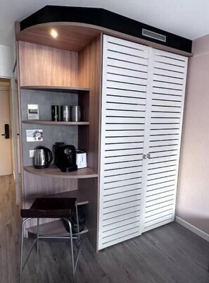 Cozy retreat with shelving unit, kettle, and coffee maker.