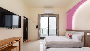 Une chambre d’hôtel avec un lit, un bureau, une télévision et une fenêtre avec des rideaux.