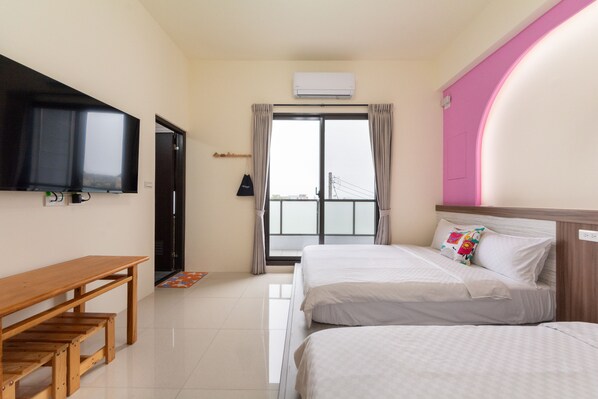 A hotel room with a bed, a desk, a TV, and a window with curtains.
