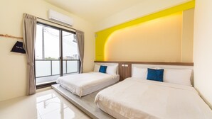 Une chambre d’hôtel avec deux lits, une grande fenêtre avec des rideaux, un appareil de climatisation et un mur d’accent jaune.
