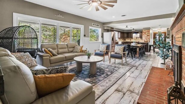 A spacious living area with a sofa, coffee table, and a view of the kitchen.