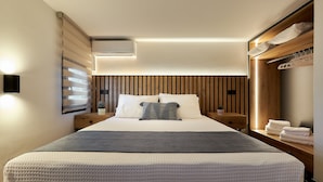 Une chambre moderne avec un grand lit, un mur revêtu de panneaux en bois et des rangements intégrés.