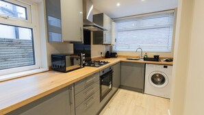 Cocina compacta con microondas, tostadora, horno y lavadora.