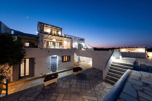 A modern two-story building with a rooftop terrace and a staircase leading to the upper level.